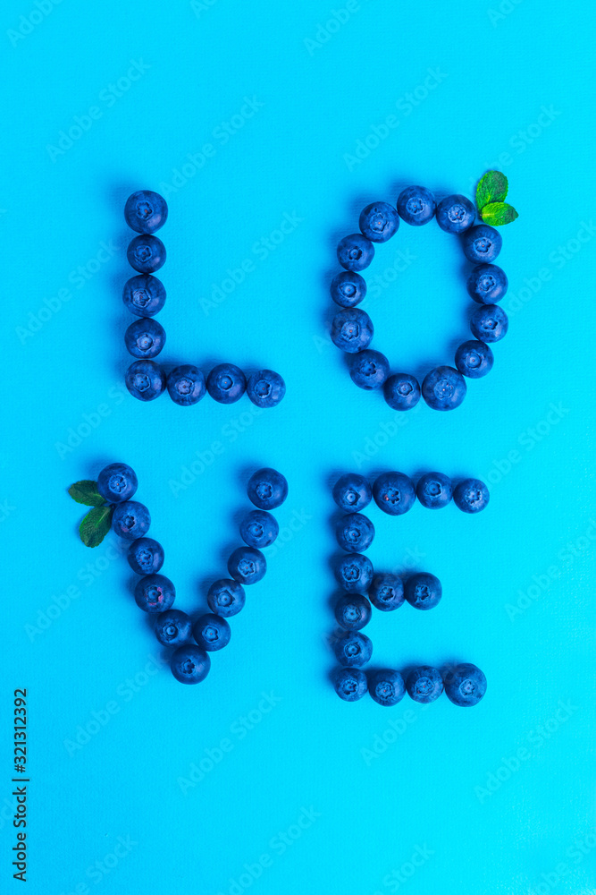 Word Love made from blueberries with mint on a blue background Word Love made from blueberries with mint on a blue background