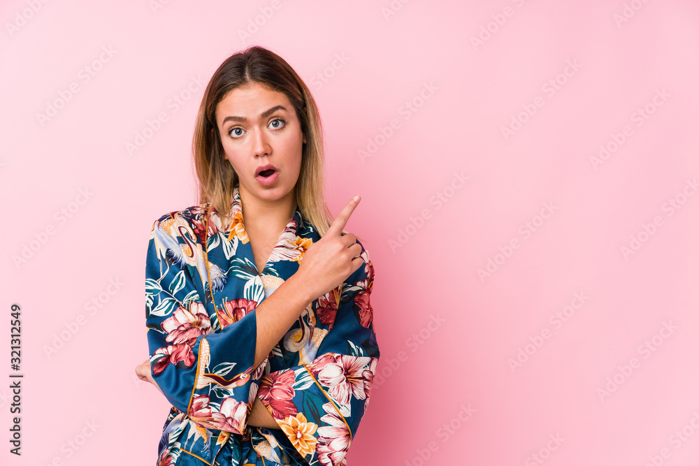 Young caucasian woman wearing pajamas pointing to the side Young caucasian woman wearing pajamas pointing to the side