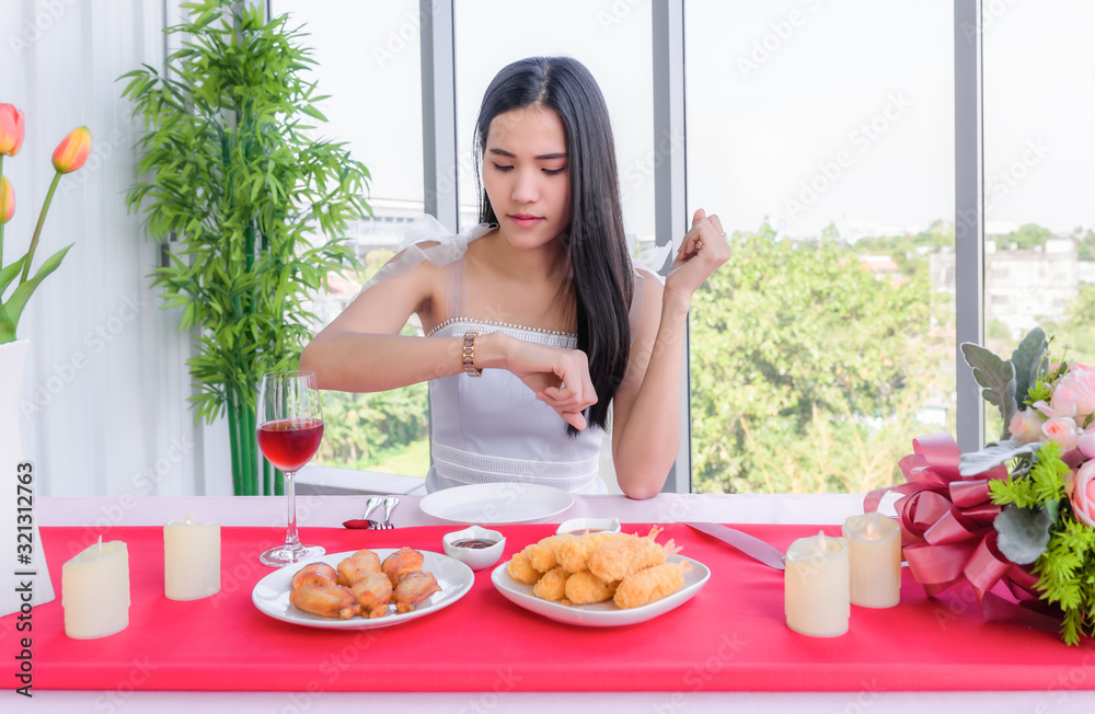 Beautiful young asian woman in white dress sitting waiting for her boyfriend in the restaurant