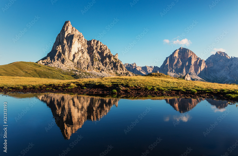 Incredible nature landscape. famous Ra Gusela under sunlight. Beautiful view of Giau Pass, Italian Dolomites, with the peaks of teh mountain reflected in a small lake, Awesome natural Background.