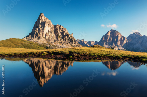 Incredible nature landscape. famous Ra Gusela under sunlight. Beautiful view of Giau Pass, Italian Dolomites, with the peaks of teh mountain reflected in a small lake, Awesome natural Background.