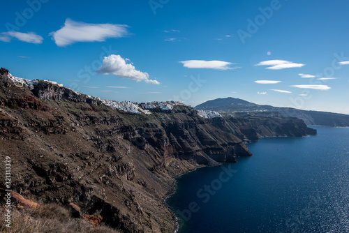 Volcanic cliffs over Aegan sea of caldera on Santorini island with panoramic view of few villages and towns including Fira (Thira)