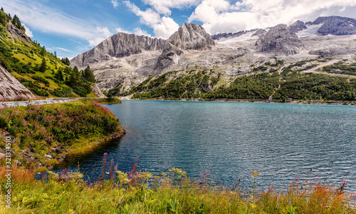 Wonderful Summer landscape. Fedaia lake with Marmolada peaks covered by ice  Dolomites  Italy. Amazing nature landscape. Picture of wild area