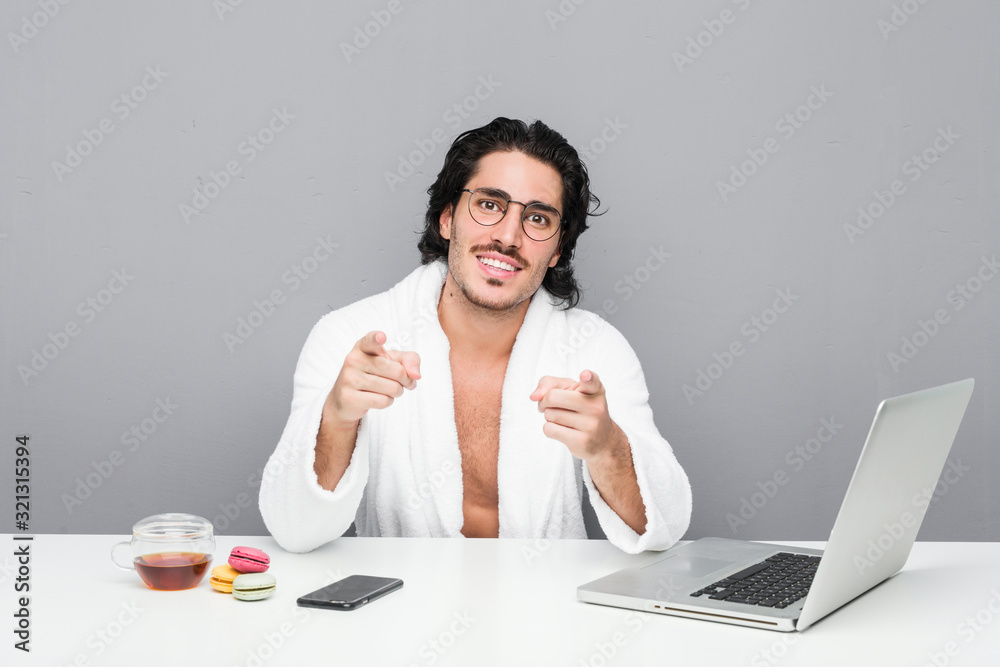 Young handsome man working after a shower cheerful smiles pointing to front. Young handsome man working after a shower cheerful smiles pointing to front.