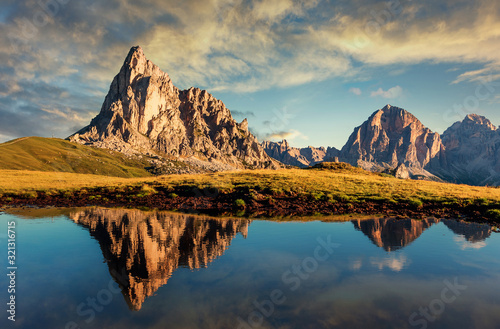 Scenic image of mountains during sunset. Great view of Giau Pass, Italian Dolomites, with the peaks of teh mountain and colorful sky reflected in a small lake, Italy.