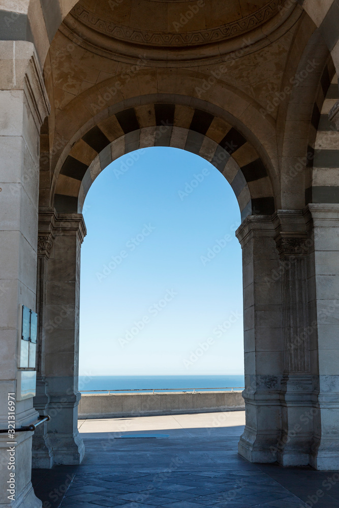 The historic Notre Dame arch in Marseille overlooking the sea on a sunny day. Vertical.