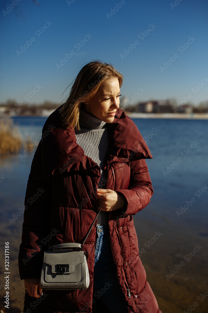 girl in a red jacket on a background of blue sky