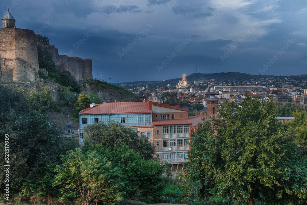 evening view of the old city of Tbilisi in Georgia, Narikala fortress and the city center against a stormy sky