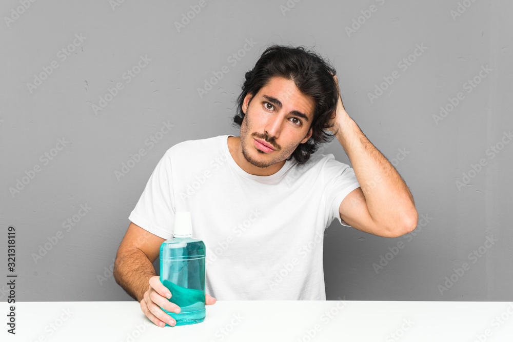 Young man holding a mouthwash being shocked, she has remembered important meeting. Young man holding a mouthwash being shocked, she has remembered important meeting.