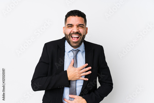 Young latin business woman against a white background isolated laughs happily and has fun keeping hands on stomach.