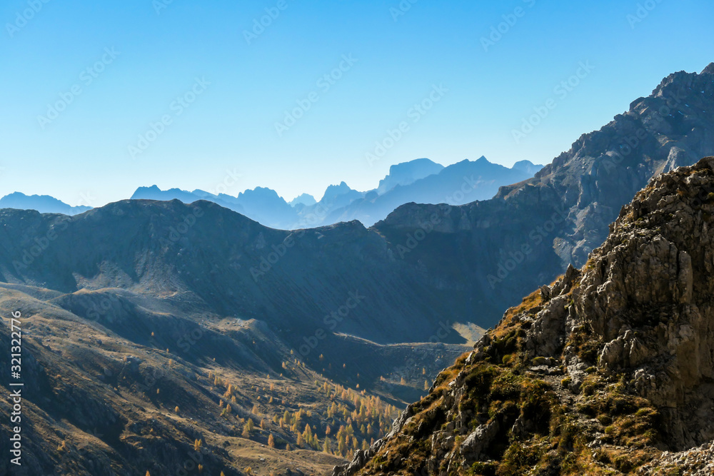 A panoramic view on Lienz Dolomites, Austria from the top of Grosse Gamswiesenspitze. The sun is slowly reaching to the lower part of the valley. High mountain climbing. Freedom and solitude
