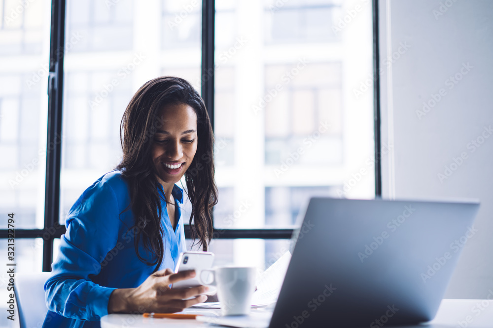 Black entrepreneur using phone in office Black entrepreneur using phone in office