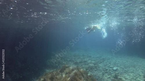 Wallpaper Mural snorkelers woman in a wetsuit swims on the surface of the water and looks at the underwater sea landscape with rocky reefs. Mediterranean Sea, Greece Torontodigital.ca