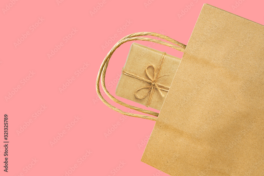 Blank brown paper shopping bag gift box on cherry pink background. Spring Easter sale presents buying for holidays mothers womens day. Eco friendly natural recyclable materials zero waste concept