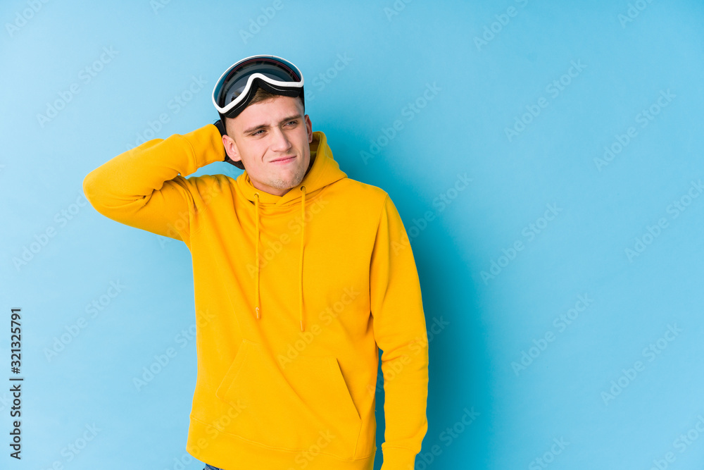 Young skier man touching back of head, thinking and making a choice.