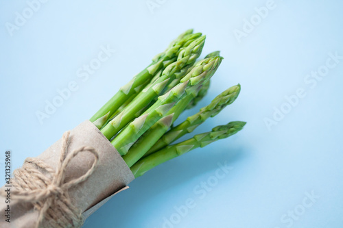 bunch of fresh green asparagus on a blue background.