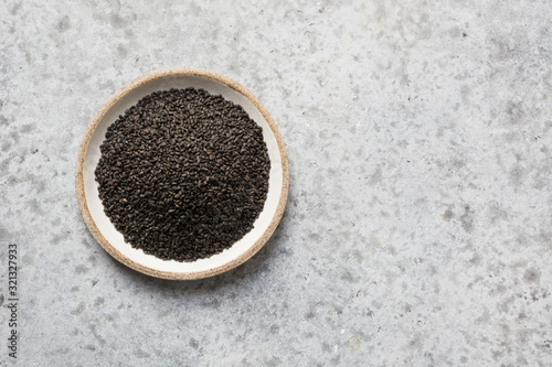 Basil or grain seeds in bowl isolated on grey background. Scientific name is Ocimum x citriodorum. Top view  space for text.