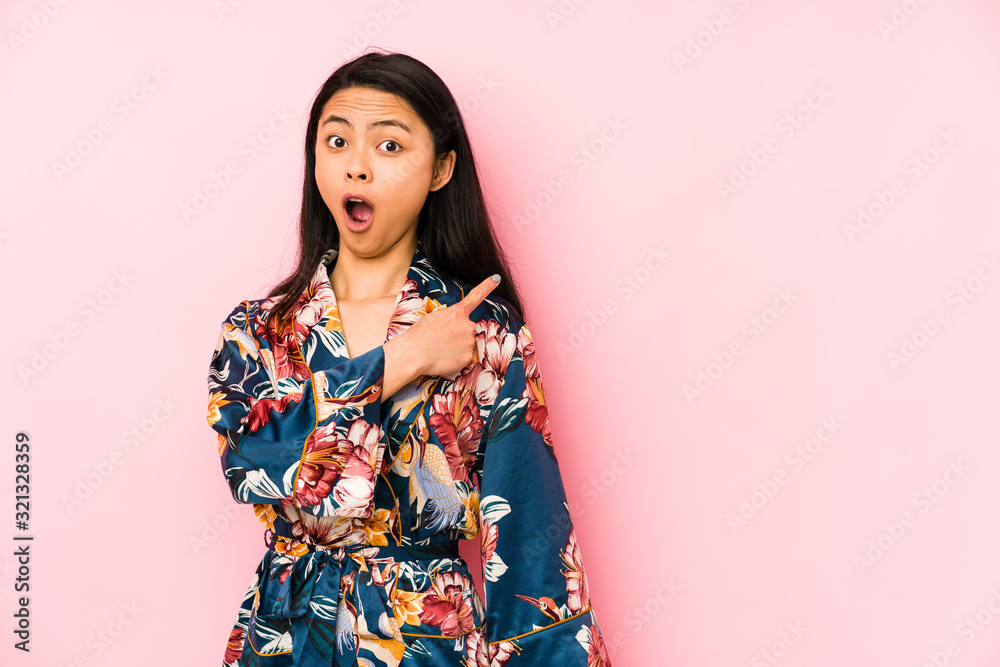 Young chinese woman wearing a asiatic pijama isolated showing number one with finger. Young chinese woman wearing a asiatic pijama isolated showing number one with finger.