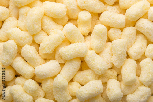 Yellow corn sticks close-up. Backgrounds and textures. Close-up shot. Delicious sweet corn sticks. A few yellow, crunchy corn snacks