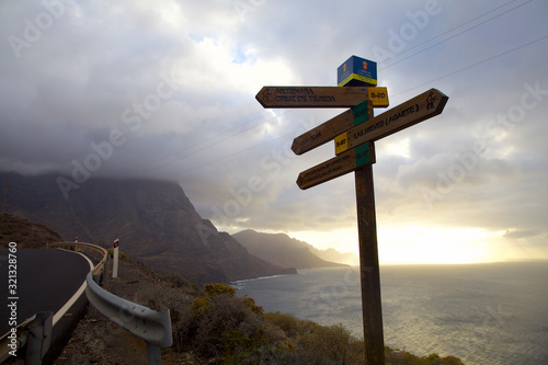 wooden signpost on background of blue sky and sunset