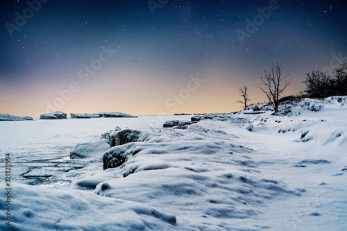 The effect of the polar vortex in the Midwest of Lake Michigan which resulted in frozen waves on the surface of the lake near Chicago, Illinois USA under a dark evening sky. photo