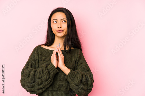 Young chinese woman isolated on a pink background making up plan in mind, setting up an idea.