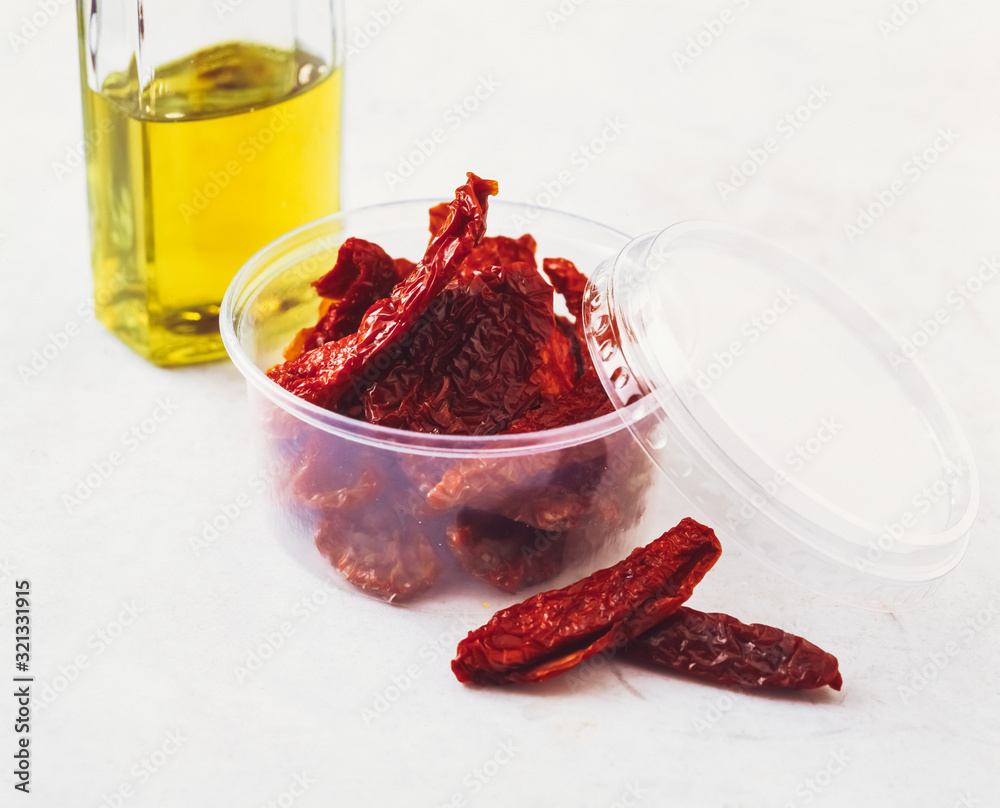 Getrocknete Tomaten mit einer Flasche olivenöl isoliert auf weißen Hintergrund Getrocknete Tomaten mit einer Flasche olivenöl isoliert auf weißen Hintergrund