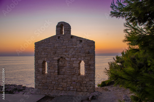 Fototapeta Naklejka Na Ścianę i Meble -  Sunset at Sveta Stijena, holy place at the Adriatic sea coast in Verudela Beach, Pula, Croatia.