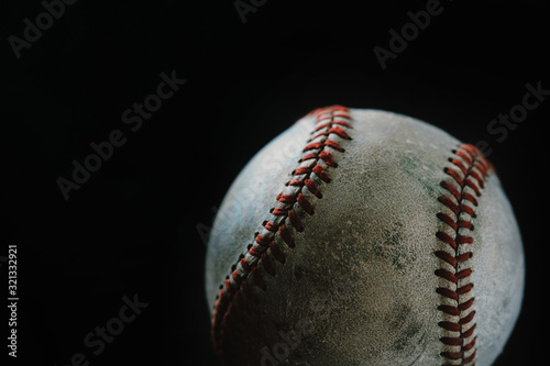 Old used vintage baseball ball close up, isolated on black background with copy space.