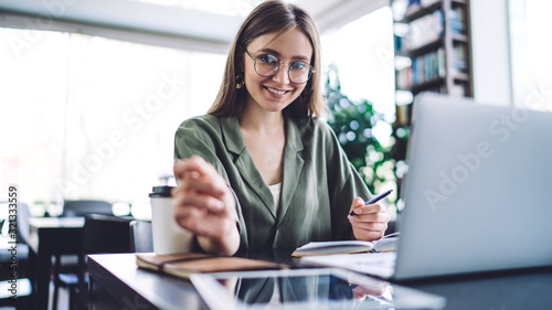 Woman with studies in library smiling at camera