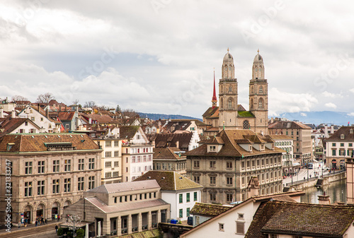 Beautiful panoramic view of historic city center of Zurich with famous Grossmunster Church, Helmhaus and Munsterbucke bridge crossing river Limmat on a cloudy winter day, Canton of Zurich,Switzerland.