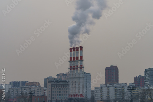 Smoking pipes with sky as background. Heat station pipes in winter. Concept of industry and ecology, heating season, modern global warming, air pollution. 