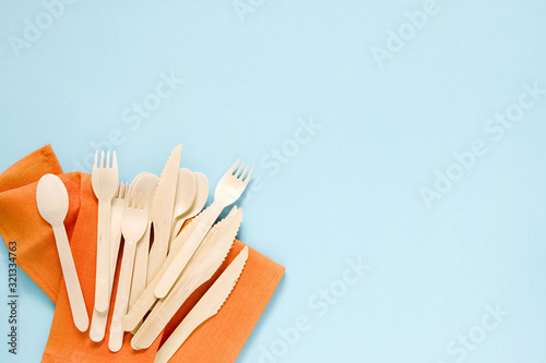 Wooden forks  spoons and knives on a blue background  top view. Disposable eco dishes 
