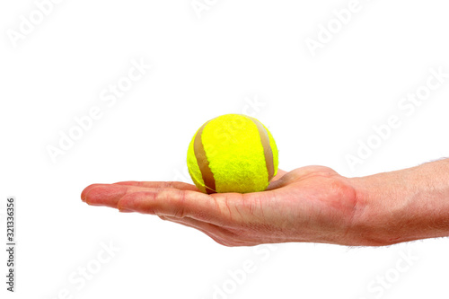 Male hand holding tennis ball isolated on white background. Minimalistic concept. © Inception