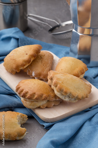 Homemade cakes with cottage cheese on a stone table with a blue napkin. Bitten cake. muffins in a baking pan on a black table. Cupcakes, muffins on a wooden board and a black wooden table. Fresh Frenc photo