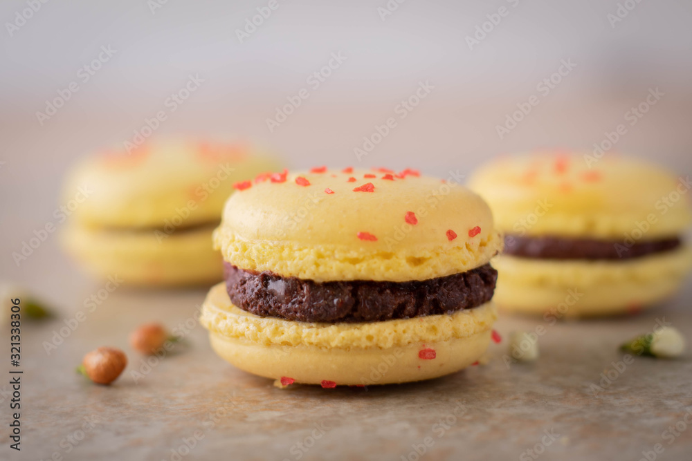 Lemon Yellow Macaron Cookies with Chocolate Filling on Tile Counter Lemon Yellow Macaron Cookies with Chocolate Filling on Tile Counter