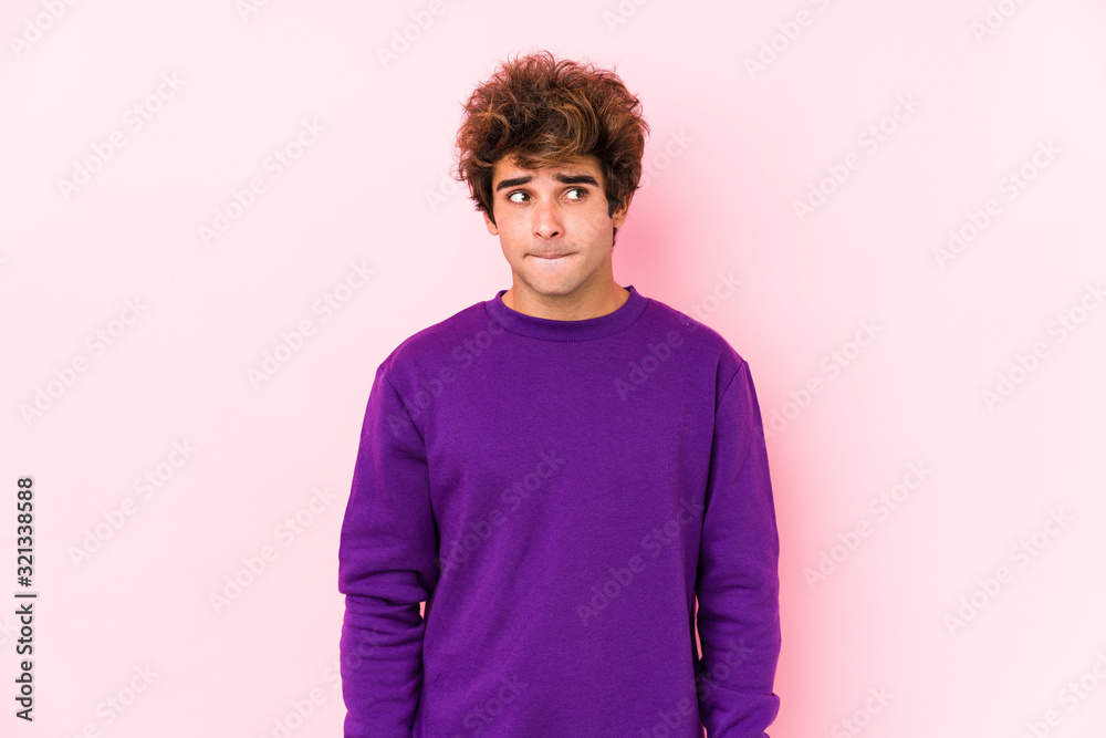 Young caucasian man against a pink background isolated confused, feels doubtful and unsure. Young caucasian man against a pink background isolated confused, feels doubtful and unsure.