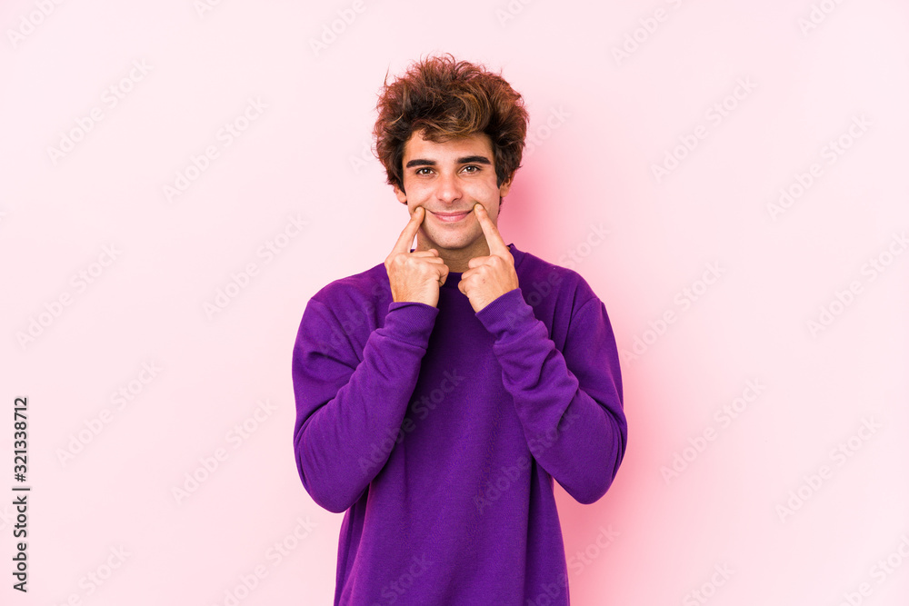 Young caucasian man against a pink background isolated doubting between two options. Young caucasian man against a pink background isolated doubting between two options.