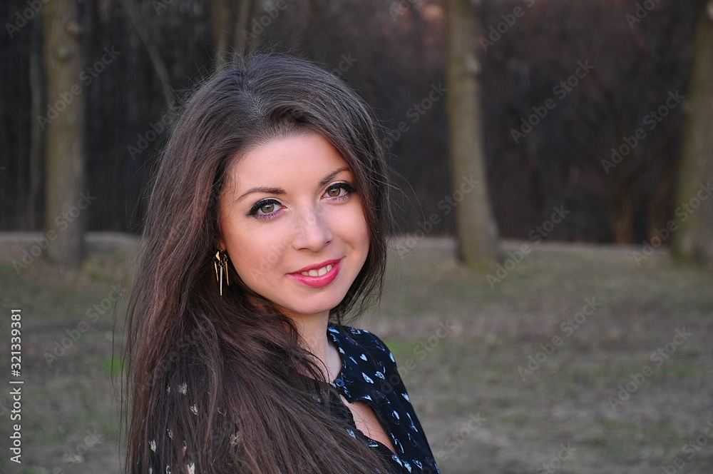 Horizontal spring portrait of a girl with bright makeup and long hair