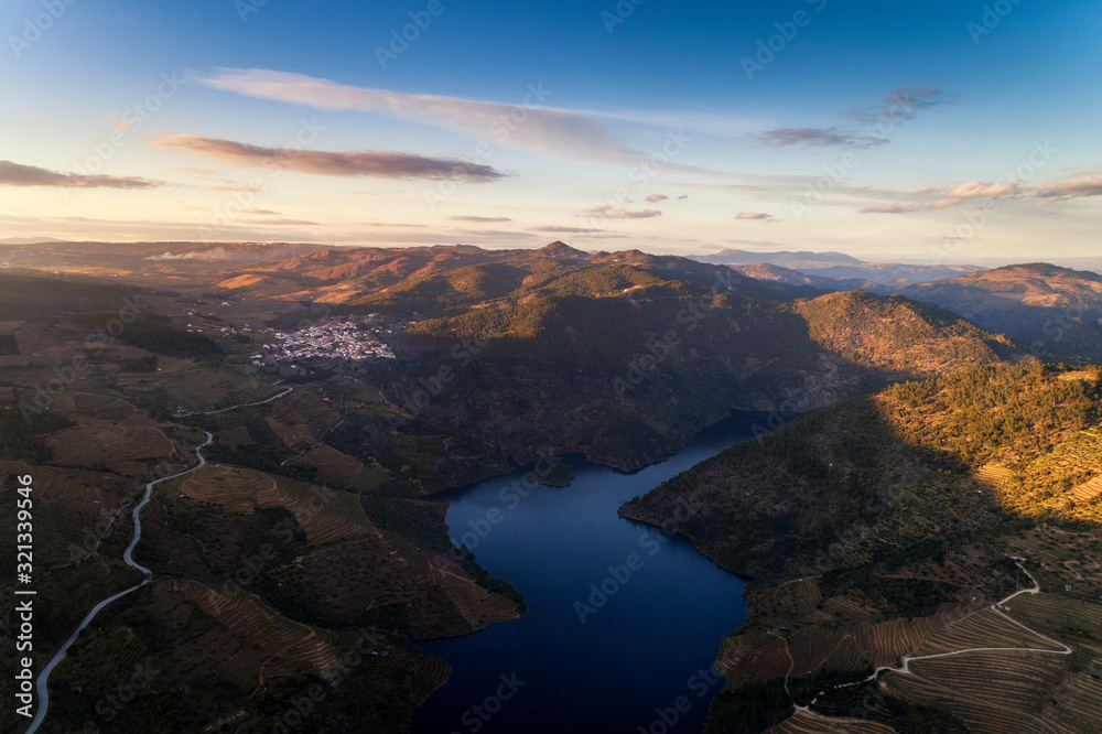 Aerial view of the Douro Valley, with the terraced vineyards, the Tua River and the village of Sao Mamede de Ribatua, in Vila Real; Concept for travel and most beautiful landscapes in Portugal