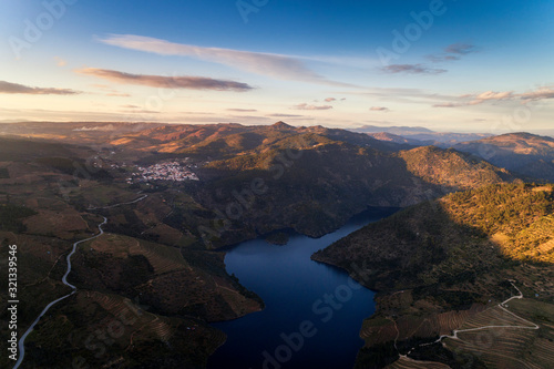 Aerial view of the Douro Valley, with the terraced vineyards, the Tua River and the village of Sao Mamede de Ribatua, in Vila Real; Concept for travel and most beautiful landscapes in Portugal