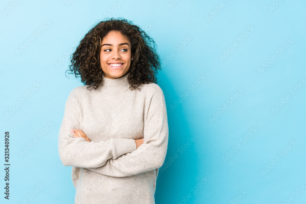 Fototapeta premium Young african american curly hair woman smiling confident with crossed arms.