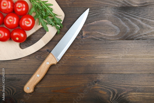 tomatoes and knife on dark wooden background with copy space flat lay