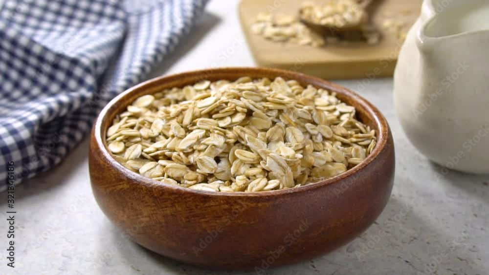 Breakfast oats being poured in slow motion. Oats are a natural and healthy cereal often used in a vegetarian diet. Breakfast oats being poured in slow motion. Oats are a natural and healthy cereal often used in a vegetarian diet.