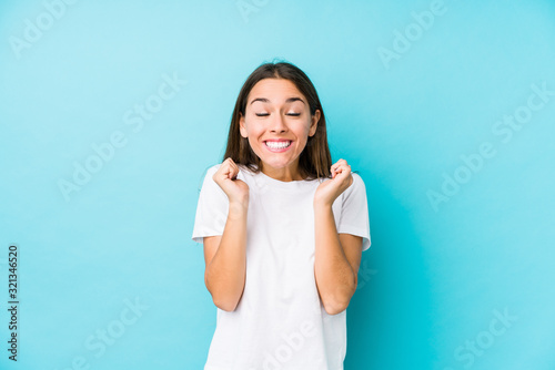 Young caucasian woman  isolated raising fist, feeling happy and successful. Victory concept.