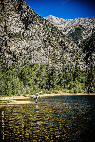 Woman fly fishing in alpine lake