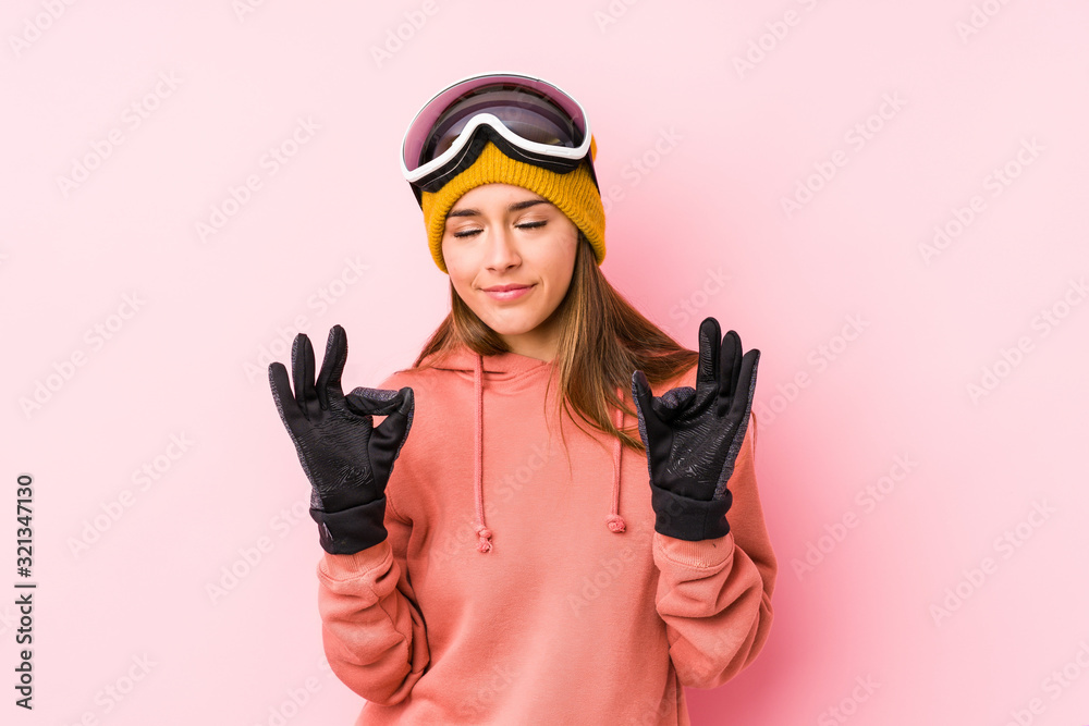 Young caucasian woman wearing a ski clothes isolated relaxes after hard working day, she is performing yoga. Young caucasian woman wearing a ski clothes isolated relaxes after hard working day, she is performing yoga.
