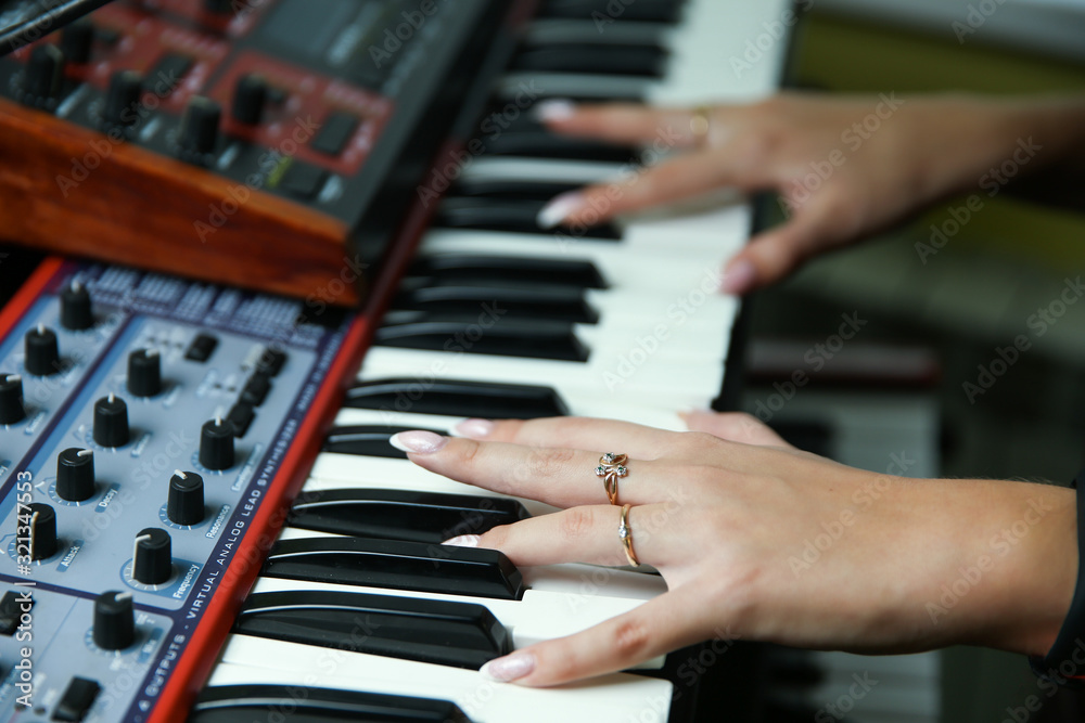 Obraz premium hands of a woman play a synthesizer close up