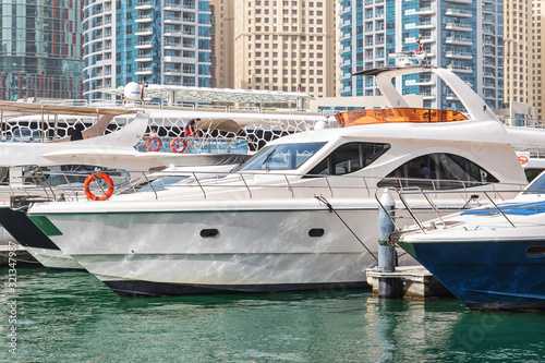 Yachts packed tight togheter at the Dubai marina with highrise resedential buildings in background © stefanholm