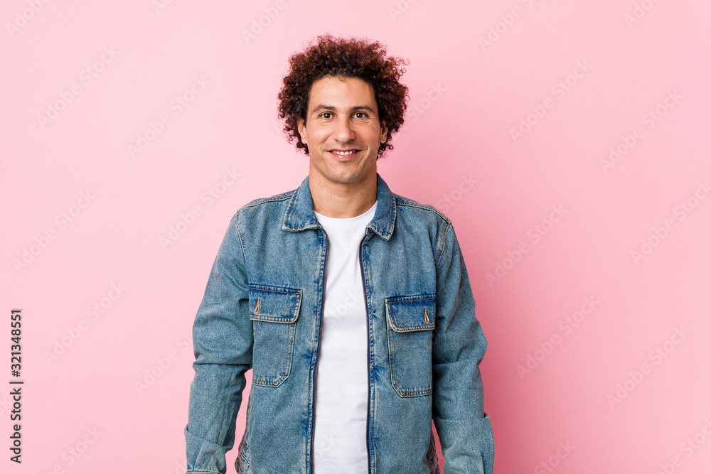 Curly mature man wearing a denim jacket against pink background happy, smiling and cheerful. Curly mature man wearing a denim jacket against pink background happy, smiling and cheerful.